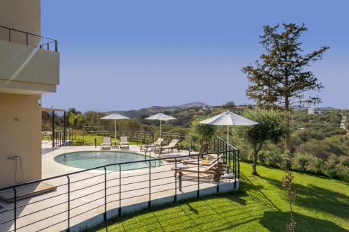 a balcony of a house with a swimming pool at AéNaos Luxury Villa with Pool in Galatas in Galatás
