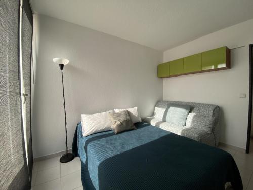 une petite chambre avec un lit et une chaise dans l'établissement Sol-y-Days la Presqu'île Ulysse 43 Marina en Triplex, au Grau-du-Roi