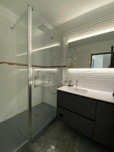 une salle de bain blanche avec une douche et un lavabo dans l'établissement Sol-y-Days la Presqu'île Ulysse 43 Marina en Triplex, au Grau-du-Roi