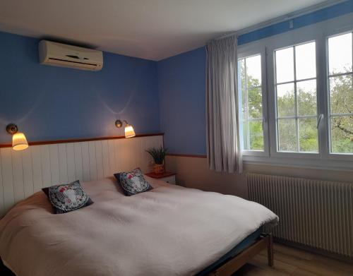 een slaapkamer met een bed met twee kussens erop bij Maison Le Petit Bonheur in Soturac