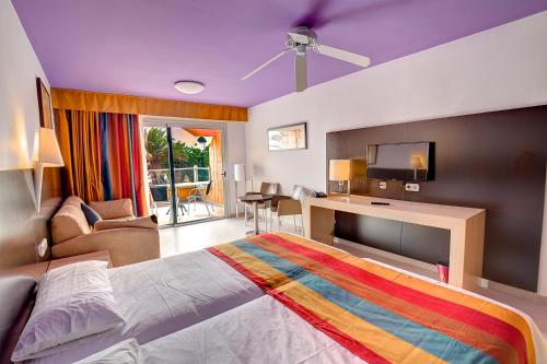 1 dormitorio con 1 cama grande con una manta colorida en SBH Monica Beach Resort, en Costa Calma