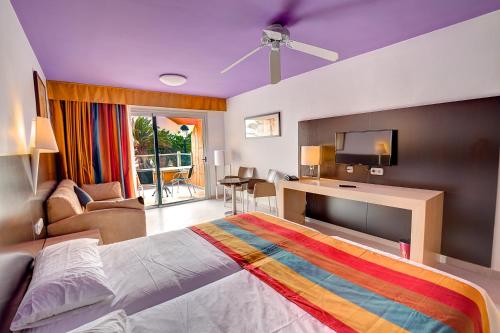 Un dormitorio con una cama grande con una manta colorida. en SBH Monica Beach Resort, en Costa Calma