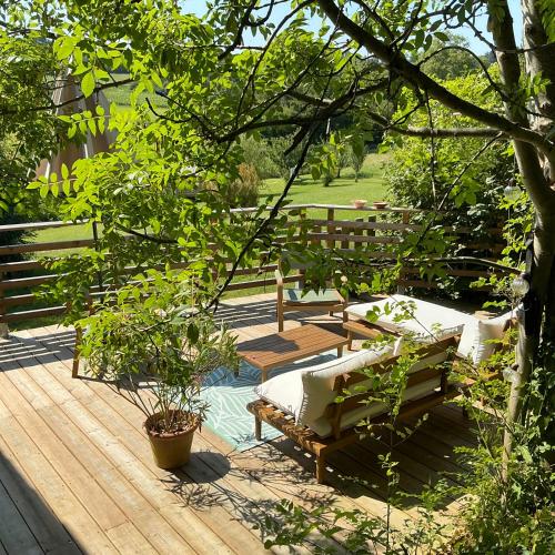 une terrasse en bois avec un banc et une table dans l'établissement Le Petit Chai Fronsadais, à Saint-Michel-de-Fronsac