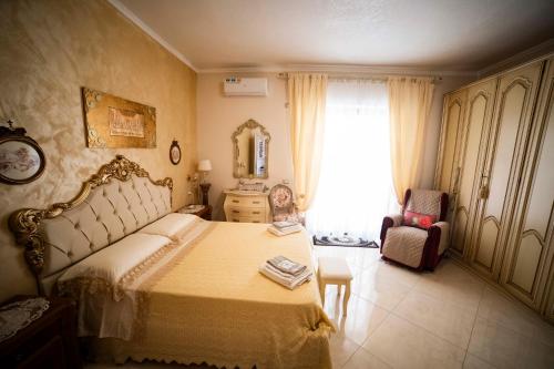a bedroom with a bed and a chair and a window at Duchessa Katia Accomodation Tropea in Tropea