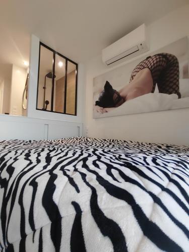 une femme allongée sur un lit dans une chambre dans l'établissement Au 69 du Village Naturiste, au Cap d'Agde