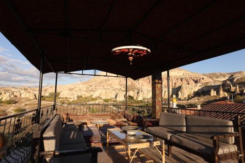 a patio with couches and a view of the mountains at Rose Valley Hotel in Goreme