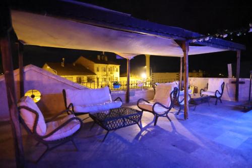 a group of chairs and a couch on a patio at night at Rose Valley Hotel in Goreme