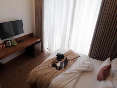 a bedroom with a bed with a laptop on it at 5mins Hostel Dalat in Da Thanh
