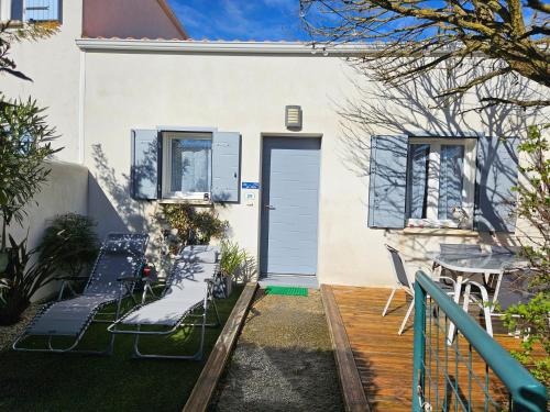 a house with a porch with chairs and a door at Maison 3 étoiles à 50m mer plages îles nature piscine chauffée jacuzzi privé WIFI in Le Port-des-Barques