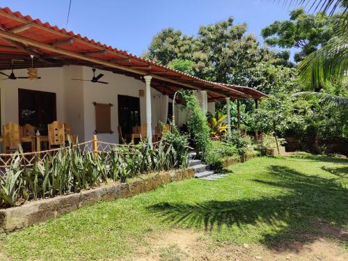 a house with a yard with plants and a house at Villa Lyvie ayurvedic hotel in Tangalle