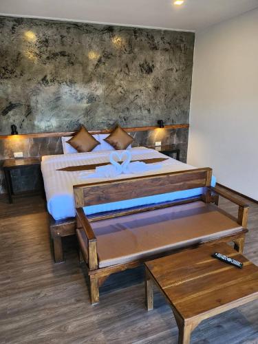 a bedroom with a large bed with wooden furniture at BuGaan Sukhothai Village in Sukhothai