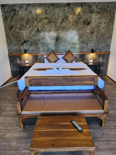 a bedroom with a bed and a remote control at BuGaan Sukhothai Village in Sukhothai