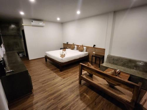 a room with a bed and two benches in it at BuGaan Sukhothai Village in Sukhothai
