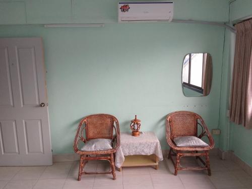 a room with a table and two chairs and a mirror at Bang Boet Homestay in Chumphon