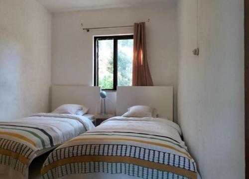 two beds in a room with a window at Country House Silves in Silves