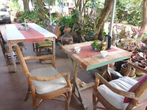 a wooden table and chairs with a table and a table and chairs at Bang Boet Homestay in Chumphon