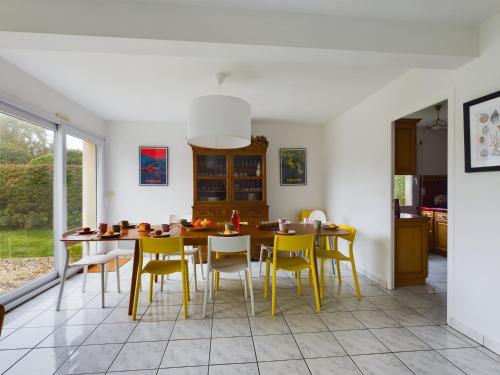 une salle à manger avec une table et des chaises jaunes dans l'établissement -NAYA- Maison familiale a deux pas de la mer, à Trégunc