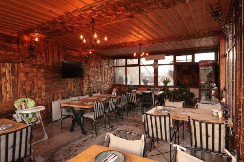 a dining room with tables and chairs and a tv at Rose Valley Hotel in Goreme