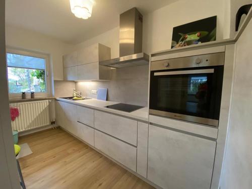 a kitchen with white cabinets and a large microwave at Gästehaus Natur in Vöhl