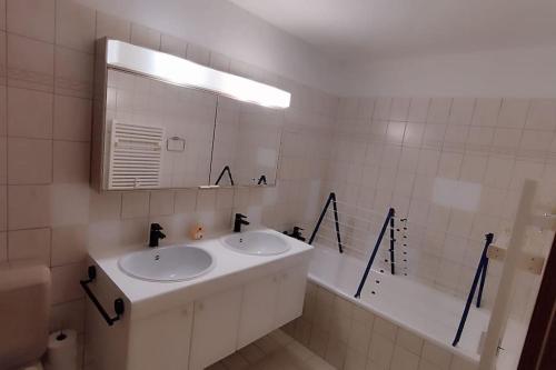 a bathroom with two sinks and a mirror and a tub at Wohlfühloase am Rheinfall in Neuhausen am Rheinfall