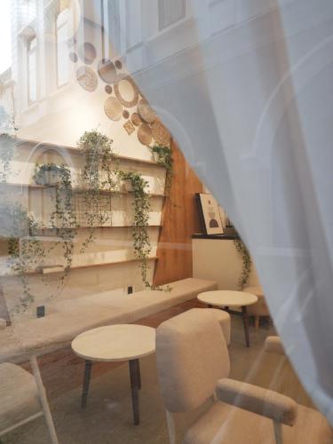 a room with tables and chairs and a staircase at 5mins Hostel Dalat in Da Thanh