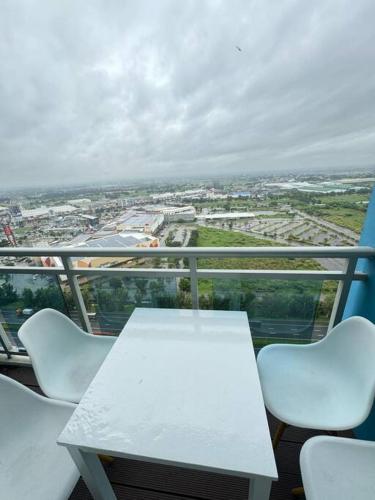 a white table and white chairs on a balcony at 2BR Mountain View Cabin - The Bali Corner at Azure North in San Fernando