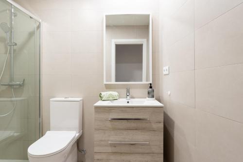 a bathroom with a toilet and a sink and a mirror at Sweet Home Santander in Santander