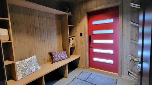 a red door in a room with a bench at Elegant black chalet with top amenities in Vrådal in Vradal