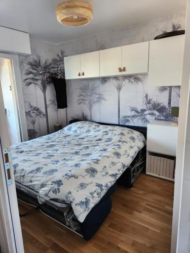 une chambre avec un lit avec une couette bleue et blanche dans l'établissement Appartement Riva Bella 2 pièces à 200 m de la mer, à Ouistreham
