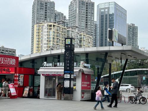 a group of people walking in a city with tall buildings at Annie 2704-only 260 metres from Metro Line 2 Exit C of BeiChun in Kunming