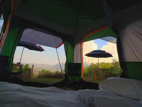 a tent with two windows and a table and an umbrella at Kintamani Adventures 'Finding Peace In The Wilderness' in Kintamani