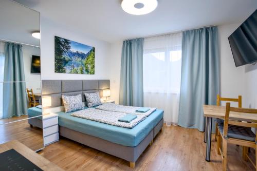a bedroom with a bed and a table in it at Apartments ALPsmart in Oetz