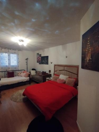 une chambre avec un lit avec une couverture rouge dans l'établissement Havre de Paix, à LʼHay-les-Roses