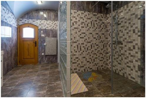 ein Bad mit einer Dusche und einer gelben Tür in der Unterkunft Katia in Grižane