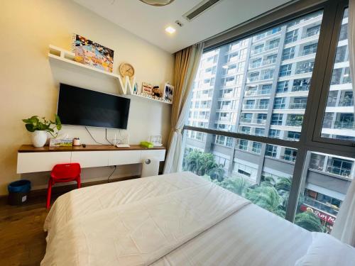 une chambre avec un lit et une grande fenêtre dans l'établissement Hana homestay- 1 Phòng ngủ trong căn hộ chủ nhà đang ở tại Park 4-Vinhome Central Park Tân cảng Bình Thạnh HCM- sát landmark 81, à Hô-Chi-Minh-Ville