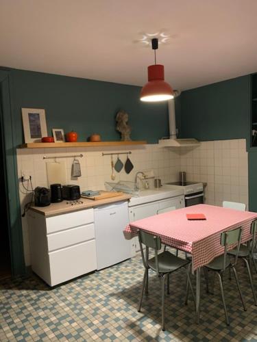 a kitchen with a table and a table and chairs at Charmant appartement sur cour, Le Cerisier in Bagnères-de-Bigorre