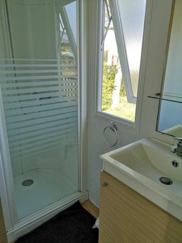 une salle de bain avec une douche en verre et un lavabo dans l'établissement Camping 4 étoiles - Parc aquatique - efcia0, à Soullans