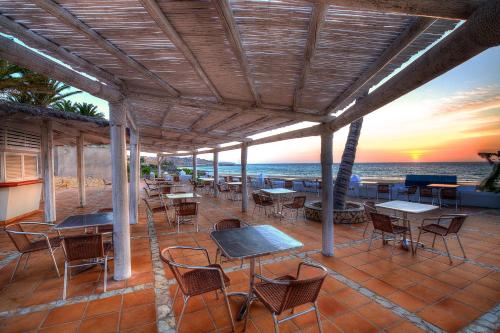 a patio with tables and chairs on the beach at SBH Monica Beach Resort in Costa Calma
