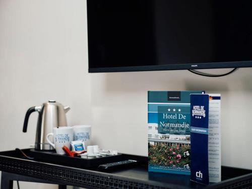 a table with a tv and a box on it at Hotel De Normandie in Saint Helier Jersey