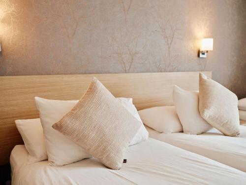 a hotel room with two beds with white pillows at Hotel De Normandie in Saint Helier Jersey