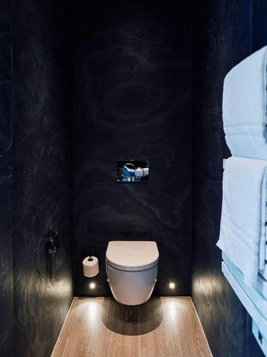 a bathroom with a white toilet in a black wall at Hotel De Normandie in Saint Helier Jersey