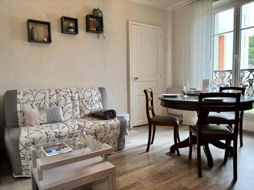 a living room with a couch and a table at Le 130 - 1 chambre - Wifi - Proche Parc Thermal - 2 personnes in Châtel-Guyon
