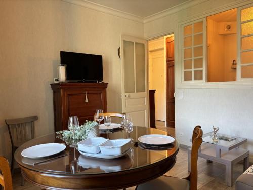 a dining room with a table and a television at Le 130 - 1 chambre - Wifi - Proche Parc Thermal - 2 personnes in Châtel-Guyon
