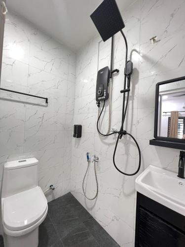 a bathroom with a shower and a toilet and a sink at Ayaani Homestay in Kuala Pilah