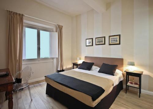 フィレンツェにあるApartments Florence Borgo dei Greciのベッドルーム(大型ベッド1台、窓付)