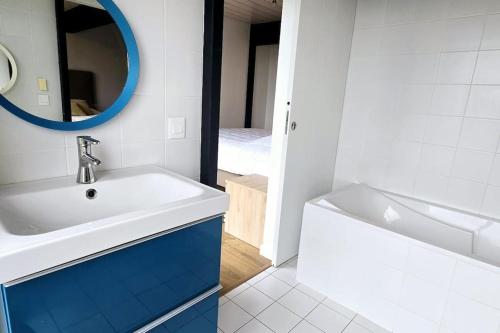 une salle de bain avec un lavabo, un miroir et une baignoire dans l'établissement Magnifique Villa Vue Lac, à Évian-les-Bains