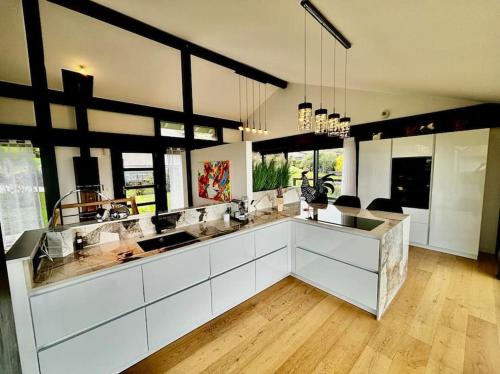 une grande cuisine avec des comptoirs et des fenêtres blancs dans l'établissement Magnifique Villa Vue Lac, à Évian-les-Bains