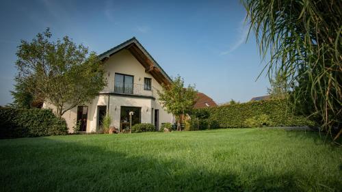 une maison avec une pelouse verte devant dans l'établissement Ferienhaus MountFrosch mit Sauna und Naturpool, à Monschau