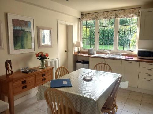 a kitchen with a table and a table and chairs at Rock House Cottage in Exeter