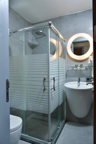 a bathroom with a shower and a toilet and a sink at Spil Suites in İzmir